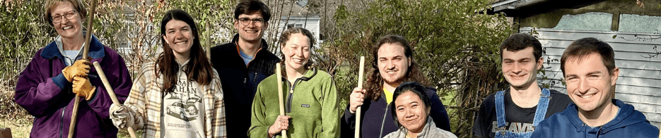 Volunteering Group of volunteers smiling, holding rakes outside.